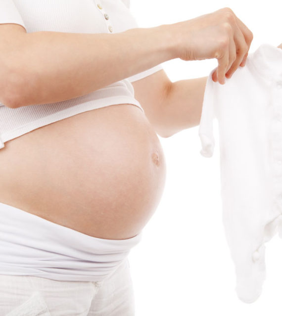 Pregnant woman holding baby grow