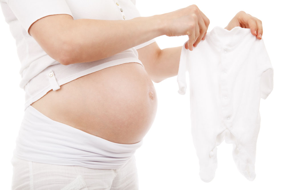 Pregnant woman holding baby grow